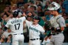 Seattle Mariners' Mitch Haniger (17) is greeted by Jake Bauers, center, after Haniger hit a two-run home run to score Bauers against the Oakland Athletics during the fifth inning of a baseball game Saturday, July 24, 2021, in Seattle. (AP Photo/Ted S. Warren)