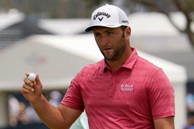 FILE - In this June 20, 2021, file photo, Jon Rahm, of Spain, waves after his putt on the first green during the final round of the U.S. Open Golf Championship at Torrey Pines Golf Course in San Diego. Rahm has tested positive for COVID-19 for the second time in two months and the Spaniard has been knocked out of the Olympics only a few hours after American golfer Bryson DeChambeau met the same fate. (AP Photo/Gregory Bull, File)