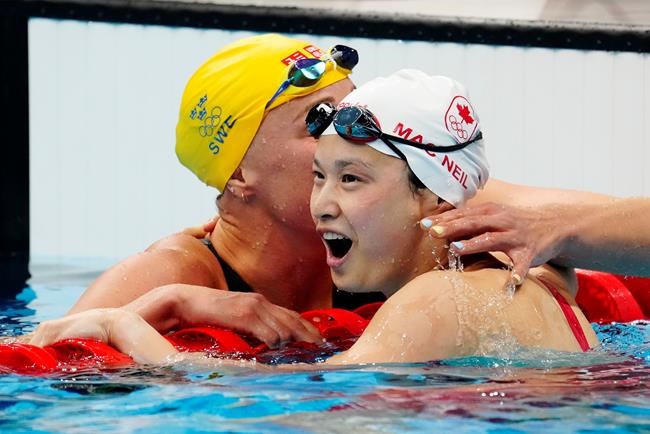 Canada's Margaret Mac Neil celebrates her gold medal swim in the women's 100m butterfly final with Sweden's Sarah Sjoestroem during the Tokyo Olympics in Tokyo, Japan on Monday, July 26, 2021. THE CANADIAN PRESS/Frank Gunn