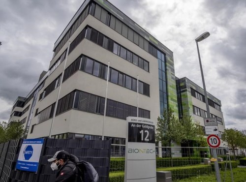 FILE - In this May 6, 2021 file photo a man with a face mask leaves the headquarters of the German biotechnology company 