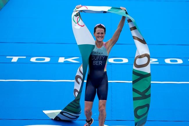 Flora Duffy of Bermuda celebrates after crossing the finish line to win the gold medal in the women's individual triathlon competition at the 2020 Summer Olympics, Tuesday, July 27, 2021, in Tokyo, Japan. (AP Photo/David Goldman)