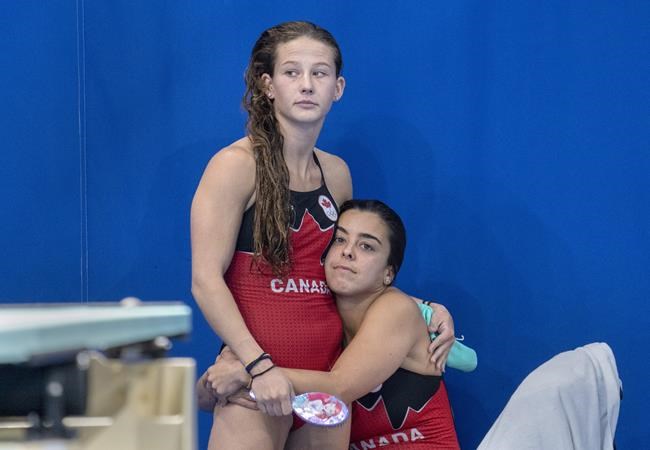 Caeli McKay (left) and Meghan Benfeito comfort each other as they see their fourth place marks in the women’s 10m synchronized diving competition during the Tokyo Olympics in Tokyo, Japan on Tuesday July 27, 2020. THE CANADIAN PRESS/ Frank Gunn