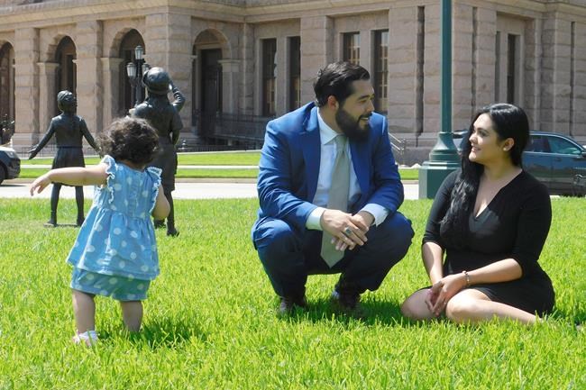 Donovon Rodriguez, chief of staff for Texas state Rep. Ray Lopez, walks around the Texas capitol with his wife, Jenny Tavarez, and daughter, Evelyn Belle Rodriguez, for whom he is the sole provider, Monday, July 26, 2021 in Austin, Texas. Rodriguez could lose his job by Sept. 1, if legislative budget funding is not restored. Texas. (AP Photo/Acacia Coronado)