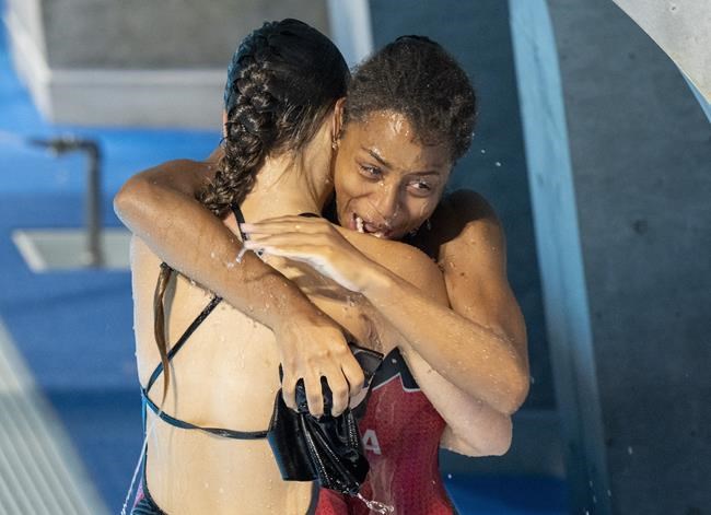 Canadian divers Jennifer Abel, right, and Melissa Citrini-Beaulieu embrace after winning silver in the women's three-metre synchronized springboard diving during the Tokyo Olympics in Tokyo, Sunday, July 25, 2020. Abel and fellow diver Pamela Ware have both qualified for the semifinals of the women's 3-metre springboard event. THE CANADIAN PRESS/Frank Gunn