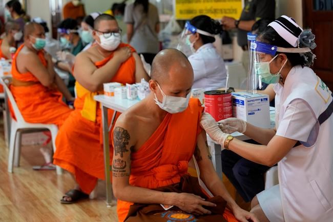 Health workers administer doses of the AstraZeneca COVID-19 vaccine to Buddhist monks at the Wat Srisudaram in Bangkok, Thailand, Friday, July 30, 2021. (AP Photo/Sakchai Lalit)