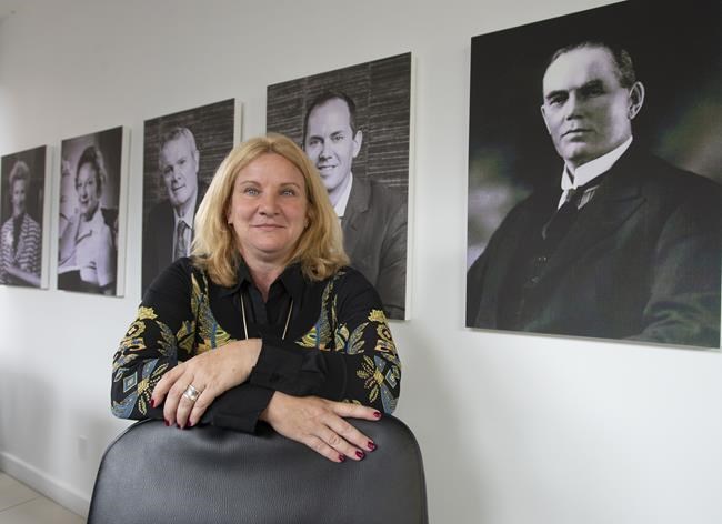 Elisabeth Laett, Holt Xchange's managing partner, is seen in front of portraits of Sir Herbert Holt, right, and other Holt family members at the company's office Friday, July 30, 2021 in Montreal. The company is in a legal battle with Credit Suisse, which operates an unrelated business called HOLT and has registered trademarks for the name HOLT. THE CANADIAN PRESS/Ryan Remiorz