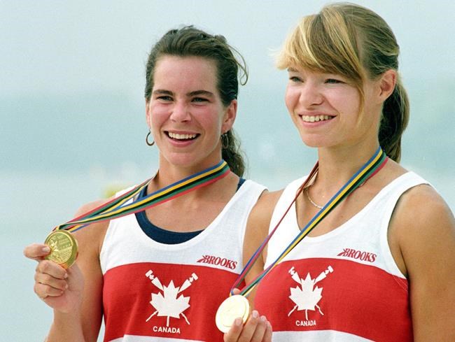 Marnie McBean, left, and Kathleen Heddle show their gold medals in the coxless pairs rowing competition at the Olympic Games in Banyoles, Spain on Aug. 1, 1992. For Mike Bryden, watching the Tokyo Olympics from his home in Vancouver has brought light and joy to his family in what has been an otherwise emotional year. Bryden is the husband of three-time Olympic rowing champion Kathleen Heddle, who died of cancer at age 55 in January. THE CANADIAN PRESS/Ron Poling