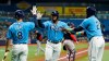 Tampa Bay Rays' Yandy Diaz, center, celebrates with Nelson Cruz, right, and Brandon Lowe, left, after scoring on a two-run double by Wander Franco off Boston Red Sox starting pitcher Martin Perez during the third inning of a baseball game Friday, July 30, 2021, in St. Petersburg, Fla. (AP Photo/Chris O'Meara)