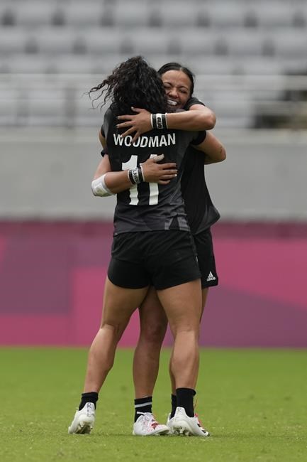 New Zealand's Stacey Fluhler, back, hugs teammate Portia Woodman, after they defeated Fiji in extra time in their women's rugby sevens semifinal match at the 2020 Summer Olympics, Saturday, July 31, 2021 in Tokyo, Japan. (AP Photo/Shuji Kajiyama)
