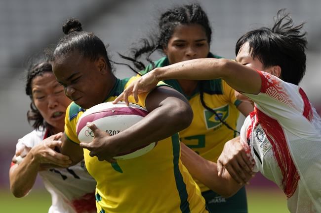 Brazil's Mariana Nicolau tries to hold onto the ball under pressure from Japan's Wakaba Hara, right, and Japan's Mifuyu Koide, in their women's rugby sevens 11-12 placing match at the 2020 Summer Olympics, Saturday, July 31, 2021 in Tokyo, Japan. (AP Photo/Shuji Kajiyama)