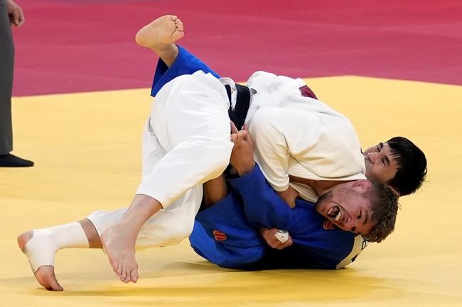 Igor Wandtke of Germany, in white, and Shohei Ono of Japan compete during their elimination round match in team judo competition at the 2020 Summer Olympics, Saturday, July 31, 2021, in Tokyo, Japan. (AP Photo/Vincent Thian)