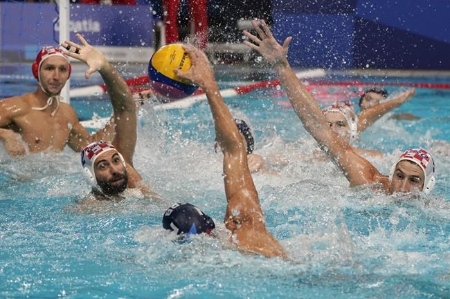 Croatia's Marko Macan (2) and Maro Jokovic (5) defend against Serbia's Strahinja Rasovic (7) during a preliminary round men's water polo match at the 2020 Summer Olympics, Saturday, July 31, 2021, in Tokyo, Japan. (AP Photo/Mark Humphrey)