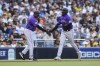 Colorado Rockies' German Marquez celebrates with third base coach Stu Cole after hitting a home run against the San Diego Padres during the fifth inning of a baseball game Saturday, July 31, 2021, in San Diego. (AP Photo/Derrick Tuskan)