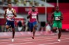 Trayvon Bromell, of United States, center, finishes a heat in the men's 100-meter run at the 2020 Summer Olympics, Saturday, July 31, 2021, in Tokyo. (AP Photo/Petr David Josek)