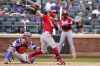 New York Mets catcher Tomas Nido looks on as Cincinnati Reds' Tyler Naquin hits an RBI double, scoring Tyler Stephenson and Max Schrock during the ninth inning of a baseball game, Sunday, Aug. 1, 2021, in New York. (AP Photo/Corey Sipkin)