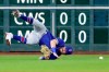 Texas Rangers left fielder David Dahl tumbles on a diving catch-attempt on a hit by Houston Astros' Michael Brantley during the third inning of a baseball game Friday, July 23, 2021, in Houston. (AP Photo/Michael Wyke)