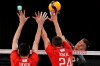Canada's Gord Perrin, right, hits the ball past Artem Volvich, of the Russian Olympic Committee, left, and Igor Kobzar, of the Russian Olympic Committee, during the men's volleyball quarterfinal match between Canada and Russian Olympic Committee at the 2020 Summer Olympics, Tuesday, Aug. 3, 2021, in Tokyo, Japan. (AP Photo/Frank Augstein)