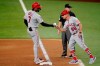 Los Angeles Angels' Jo Adell, left, celebrates his run-scoring single with first base coach Bruce Hines (99) in the seventh inning of a baseball game against the Texas Rangers as umpire Nick Mahrley stands by the bag in Arlington, Texas, Tuesday, Aug. 3, 2021. (AP Photo/Tony Gutierrez)