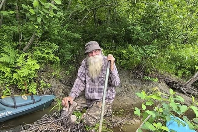 In this undated photo provided by Jodie Gedeon, David Lidstone, 81, smiles in the woods of Canterbury, N.H. Lidstone has lived in the woods along the Merrimack River for nearly three decades in a shack, growing his own food and cutting his firewood. He's now jailed after not complying with a court order to leave, and there's a growing petition to just let