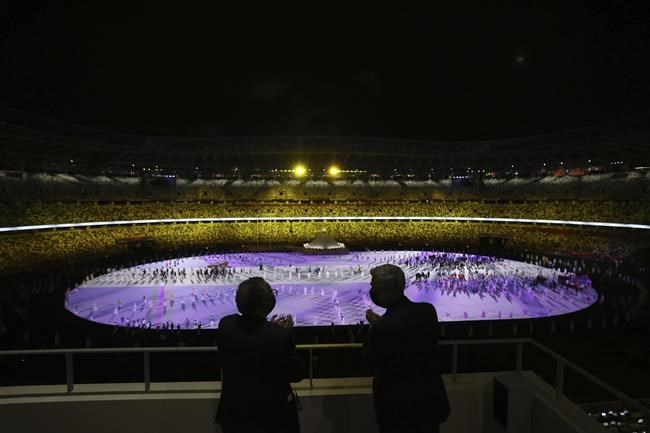 World Health Organization Director-General Tedros Adhanom Ghebreyesus, left, and United Nations High Commissioner for Refugees Filippo Grandi watch the opening ceremony in the Olympic Stadium at the 2020 Summer Olympics, Friday, July 23, 2021, in Tokyo, Japan. (Leon Neal/Pool Photo via AP)