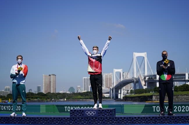 Florian Wellbrock, center, of Germany, celebrates his gold medal as he is flanked by silver medalist Kristof Rasovszky, left, of Hungary, and bronze medalist Gregorio Paltrinieri, of Italy, during a victory ceremony for the men's marathon swimming event at the 2020 Summer Olympics, Thursday, Aug. 5, 2021, in Tokyo, Japan. (AP Photo/Jae C. Hong)
