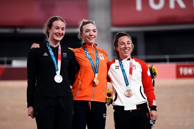 Gold medallist Shanne Braspennincx of Team Netherlands, center, celebrates on the podium with silver medallist Ellesse Andrews of Team New Zealand, left, and bronze medallist Lauriane Genest of Team Canada, during a medal ceremony for the track cycling women's keirin at the 2020 Summer Olympics, Thursday, Aug. 5, 2021, in Izu, Japan. THE CANADIAN PRESS/AP/Thibault Camus