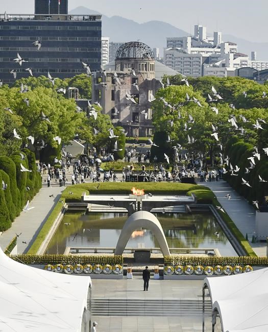 Doves fly over the cenotaph dedicated to the victims of the atomic bombing during a ceremony to mark the anniversary of the bombing at Hiroshima Peace Memorial Park in Hiroshima, western Japan Friday, Aug. 6, 2021. Hiroshima on Friday marked the 76th anniversary of the world's first atomic bombing of the city. (Shingo Nishizume/Kyodo News via AP)