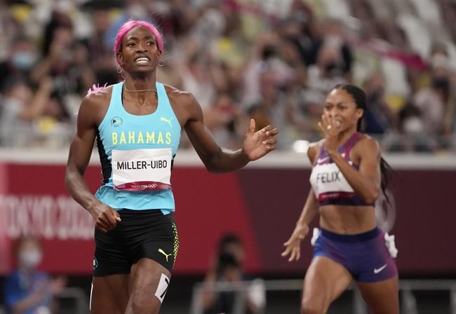 Shaunae Miller-Uibo, of Bahamas crosses the line to win the gold medal ahead of Allyson Felix, of United States, bronze, in the final of women's 400-meters at the 2020 Summer Olympics, Friday, Aug. 6, 2021, in Tokyo, Japan. (AP Photo/Charlie Riedel)