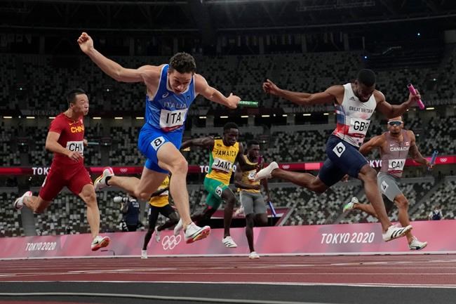 Filippo Tortu, of Italy, crosses the finish line ahead of Nethaneel Mitchell-Blake, of Britain, to lead his to team a gold medal in the men's 4x100-meter relay at the 2020 Summer Olympics, Friday, Aug. 6, 2021, in Tokyo. (AP Photo/David J. Phillip)