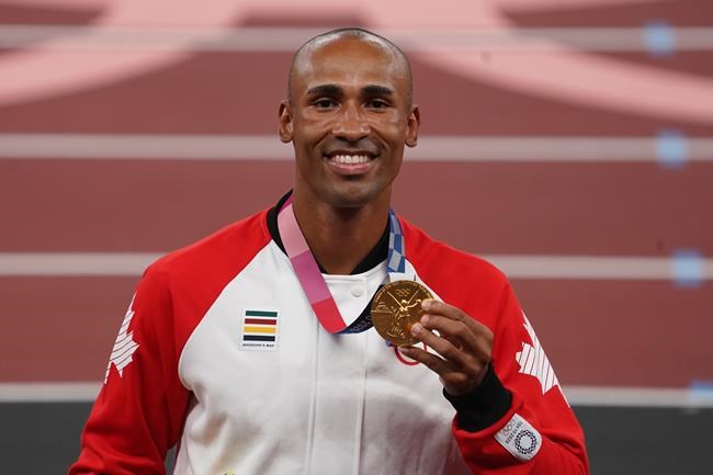 Canada's Damian Warner holds up his gold medal during the medal ceremony for men's decathlon at the Tokyo Olympics in Tokyo, Japan on Friday, Aug.6, 2021. THE CANADIAN PRESS/Nathan Denette