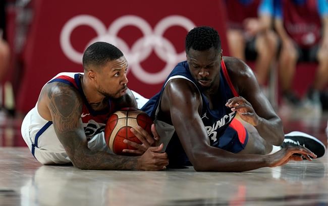 United States' Damian Lillard (6), left, and France's Moustapha Fall (93) fight for a loose ball during men's basketball gold medal game at the 2020 Summer Olympics, Saturday, Aug. 7, 2021, in Saitama, Japan. (AP Photo/Charlie Neibergall)