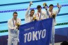 FILE - In this Aug. 1, 2021, file photo, members of the U.S. men's 4x100-meter medley relay team, Caeleb Dressel, Zach Apple, Ryan Murphy and Michael Andrew, carry a sign that reads, 