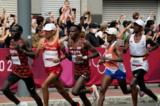Fans watches as runners compete during the men's marathon at the 2020 Summer Olympics, Sunday, Aug. 8, 2021, in Sapporo, Japan. THE CANADIAN PRESS/AP-Eugene Hoshiko