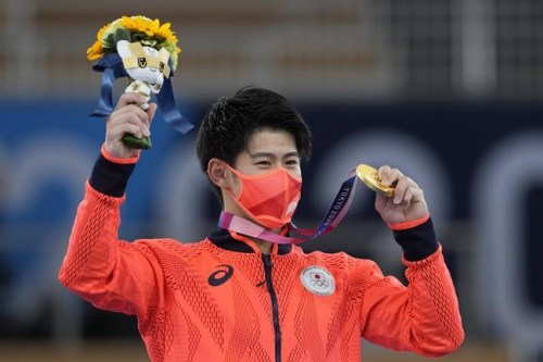 FILE - In this July 28, 2021, file photo, Daiki Hashimoto, of Japan, poses with his gold medal for the artistic gymnastics men's all-around final at the 2020 Summer Olympics in Tokyo. Despite the pandemic, the one-year delay and the soaring costs, the Japanese public may still find a sweet spot for these Olympics, the way it did for the storied 1964 Games. Why? A historic haul of medals. Japan had its best Olympics in every category: the most gold medals (27), the most overall (58), and a third-place finish in both categories behind two much larger countries - the United States and China. (AP Photo/Natacha Pisarenko, File)