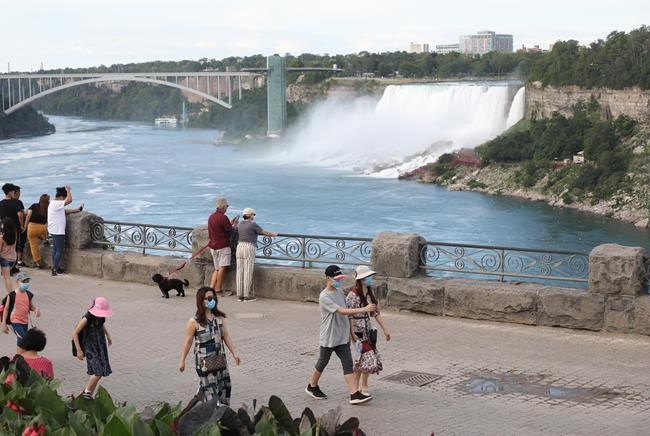A sparse crowd is seen on the normally jammed walkway in Niagara Falls, Ont., on Monday, July 13, 2020. Businesses in the Niagara Region are eager to welcome American visitors back for the first time in more than a year as restrictions at the border ease on Monday. THE CANADIAN PRESS/Colin Perkel