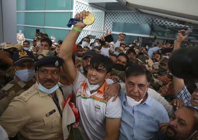 Olympic medallist Neeraj Chopra displays the gold medal he won in the men’s javelin at the Tokyo Games as he arrives for a rousing reception at the Indira Gandhi International Airport in New Delhi, India, Monday, Aug.9, 2021. (AP Photo)