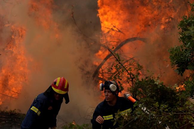 Firefighters operate at Ellinika village on Evia island, about 176 kilometers (110 miles) north of Athens, Greece, Monday, Aug. 9, 2021. Firefighters and residents battled a massive forest fire on Greece's second largest island for a seventh day Monday, fighting to save what they can from flames that have decimated vast tracts of pristine forest, destroyed homes and businesses and sent thousands fleeing. (AP Photo/Petros Karadjias)