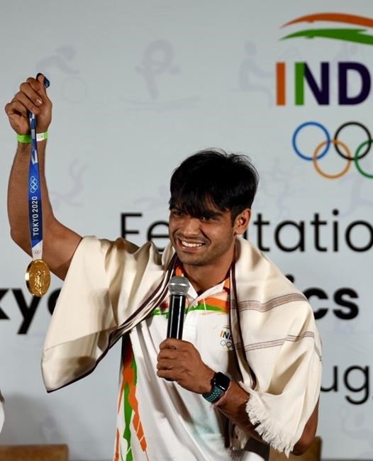 Olympic medallist Neeraj Chopra displays the gold medal he won in the men’s javelin at the Tokyo Games during a felicitation function at Major Dhyan Chand National Stadium in New Delhi, India, Monday, Aug.9 2021. (AP Photo/Manish Swarup)