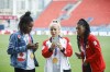 From left, Canadian women's soccer players Kadeisha Buchanan, Adriana Leon, and Ashley Lawrence look at photos on their phone as they show off their gold medals from the Tokyo Olympics, at BMO Field in Toronto during a media availability on Aug. 10, 2021. THE CANADIAN PRESS/Cole Burston