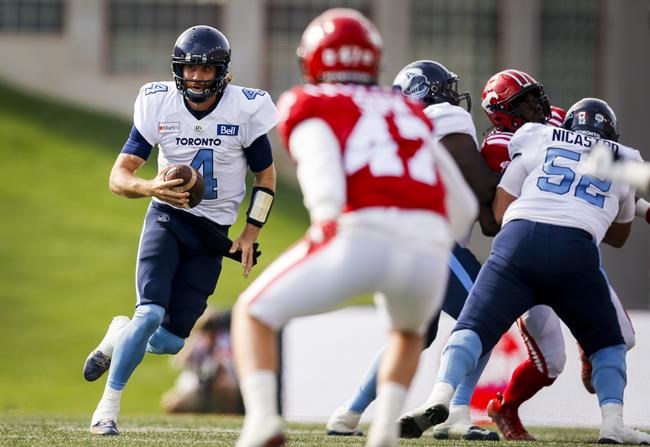 Toronto Argonauts quarterback McLeod Bethel-Thompson, left, looks for an opening as he runs the ball against the Calgary Stampeders during CFL football action in Calgary, Saturday, Aug. 7, 2021. Toronto (1-0) visits the Winnipeg Blue Bombers on Friday night. THE CANADIAN PRESS/Jeff McIntosh