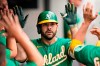 Oakland Athletics' Mitch Moreland is congratulated by teammates after hitting a solo home run in the fifth inning of a baseball game against the Cleveland Indians, Thursday, Aug. 12, 2021, in Cleveland. (AP Photo/Tony Dejak)