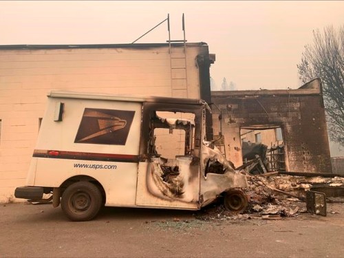 The remains of a burned U.S Postal truck is seen in Greenville, Calif., after the Dixie Wildfires Thursday, Aug. 12, 2021. California's largest single wildfire in recorded history is running through forestlands as fire crews try to protect rural communities from flames that have destroyed hundreds of homes. The Dixie Fire is the largest single fire in California history and the largest currently burning in the U.S. It is about half the size of the August Complex, a series of lightning-caused 2020 fires across seven counties that were fought together and that state officials consider California's largest wildfire overall. (AP Photo/Eugene Garcia)