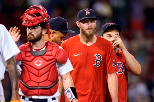 Boston Red Sox pitcher Chris Sale, center, who is on the disabled list, walks with teammates after a 20-8 win against the Tampa Bay Rays after a baseball game at Fenway Park, Wednesday, Aug. 11, 2021, in Boston. (AP Photo/Charles Krupa)