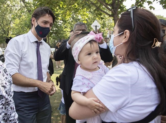 Prime Minister Justin Trudeau talks with a family following childcare funding announcement in Montreal on Thursday, August 5, 2021. THE CANADIAN PRESS/Graham Hughes