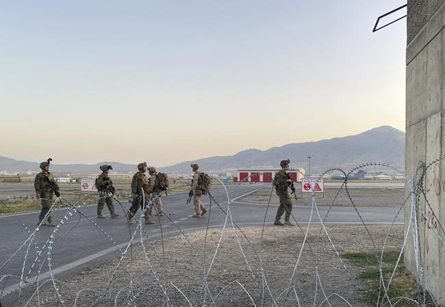 U.S. soldiers stand guard along a perimeter at the international airport in Kabul, Afghanistan, Monday, Aug. 16, 2021. On Monday, the U.S. military and officials focus was on Kabul’s airport, where thousands of Afghans trapped by the sudden Taliban takeover rushed the tarmac and clung to U.S. military planes deployed to fly out staffers of the U.S. Embassy, which shut down Sunday, and others. (AP Photo/Shekib Rahmani)