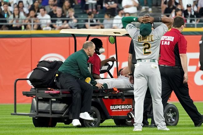 Oakland Athletics' Starling Marte (2) reacts as starting pitcher Chris Bassitt is taken off the field after being hit in the head by a ball hit by Chicago White Sox's Brian Goodwin during the second inning of a baseball game, Tuesday, Aug. 17, 2021, in Chicago. (AP Photo/Charles Rex Arbogast)