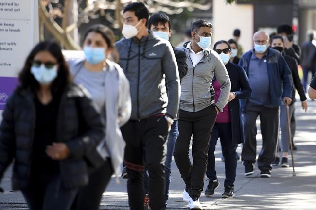 People wait in line to get vaccinated at a COVID-19 vaccination clinic in Sydney, Wednesday, Aug. 18, 2021. Australia's most populous state reported a record 633 new coronavirus infections on Wednesday as concerns grew about the delta variant's spread beyond Sydney. (Dan Himbrechts/AAP Image via AP)