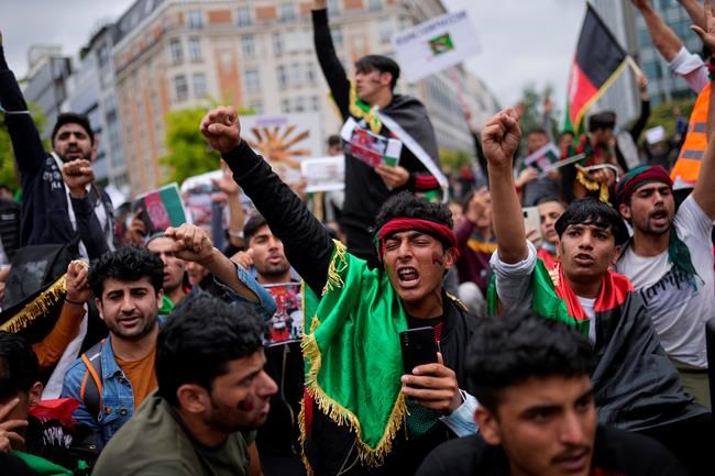 Demonstrators raise their fists during a protest to raise awareness regarding the situation in Afghanistan outside EU headquarters in Brussels, Wednesday, Aug. 18, 2021. The European Union has no immediate plans to recognize the Taliban after their sweeping victory in Afghanistan but will talk with the militants to ensure that European nationals and Afghans who have worked with the EU can leave safely, the bloc's top diplomat said Tuesday. (AP Photo/Francisco Seco)
