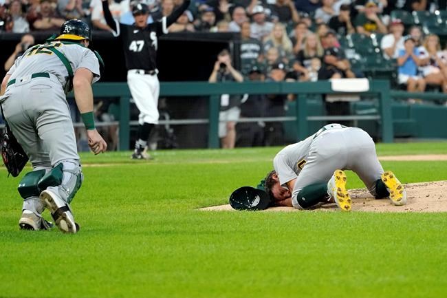 Oakland Athletics catcher Sean Murphy runs to starting pitcher Chris Bassitt after Bassitt was hit in the head from a ball hit by Chicago White Sox's Brian Goodwin during the second inning of a baseball game, Tuesday, Aug. 17, 2021, in Chicago. (AP Photo/Charles Rex Arbogast)
