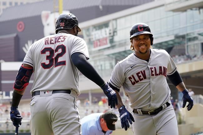 Cleveland Indians' Jose Ramirez, right, scores on his solo home run off Minnesota Twins pitcher Lewis Thorpe in the first inning of a baseball game, Wednesday, Aug. 18, 2021, in Minneapolis. (AP Photo/Jim Mone)